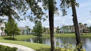 Área residencial com lago, casas e calçada.