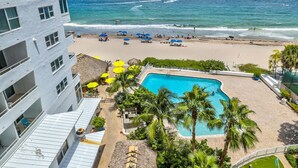 Un hôtel doté d’une piscine, d’une plage et offrant une vue sur l’océan.