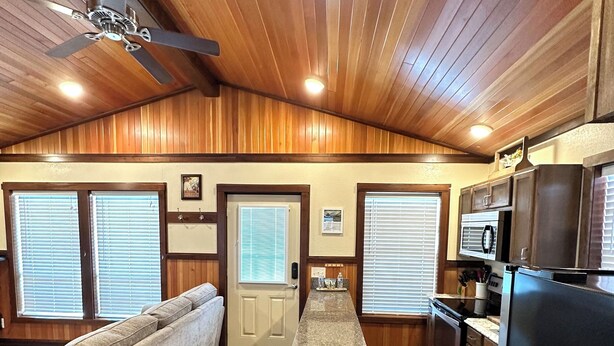 A compact kitchen with wooden cabinets, a refrigerator, and a microwave.
