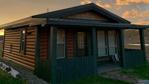 A small, single-story cabin with a gabled roof, a front porch, and a number '3' on the door.