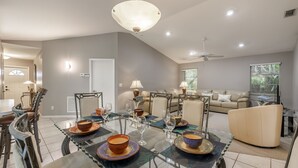 A modern dining area with a glass table set for four, surrounded by chairs. - Pool Table, Bicycles, Pool & Spa --ESCAPE - Caribbean Getaway - Roelens Vacations (Cape Coral)