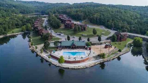 An aerial view of a lakeside resort with a central pool area, multiple buildings, and a dock. - Rustic Stonebridge Cabin, near Silver Dollar City Pools>Golf>Lake>Nature (Branson West)