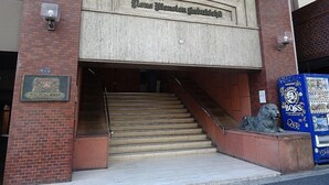 En byggnadsingång med en skylt som lyder: ”Stenhuset Gubikholms”.