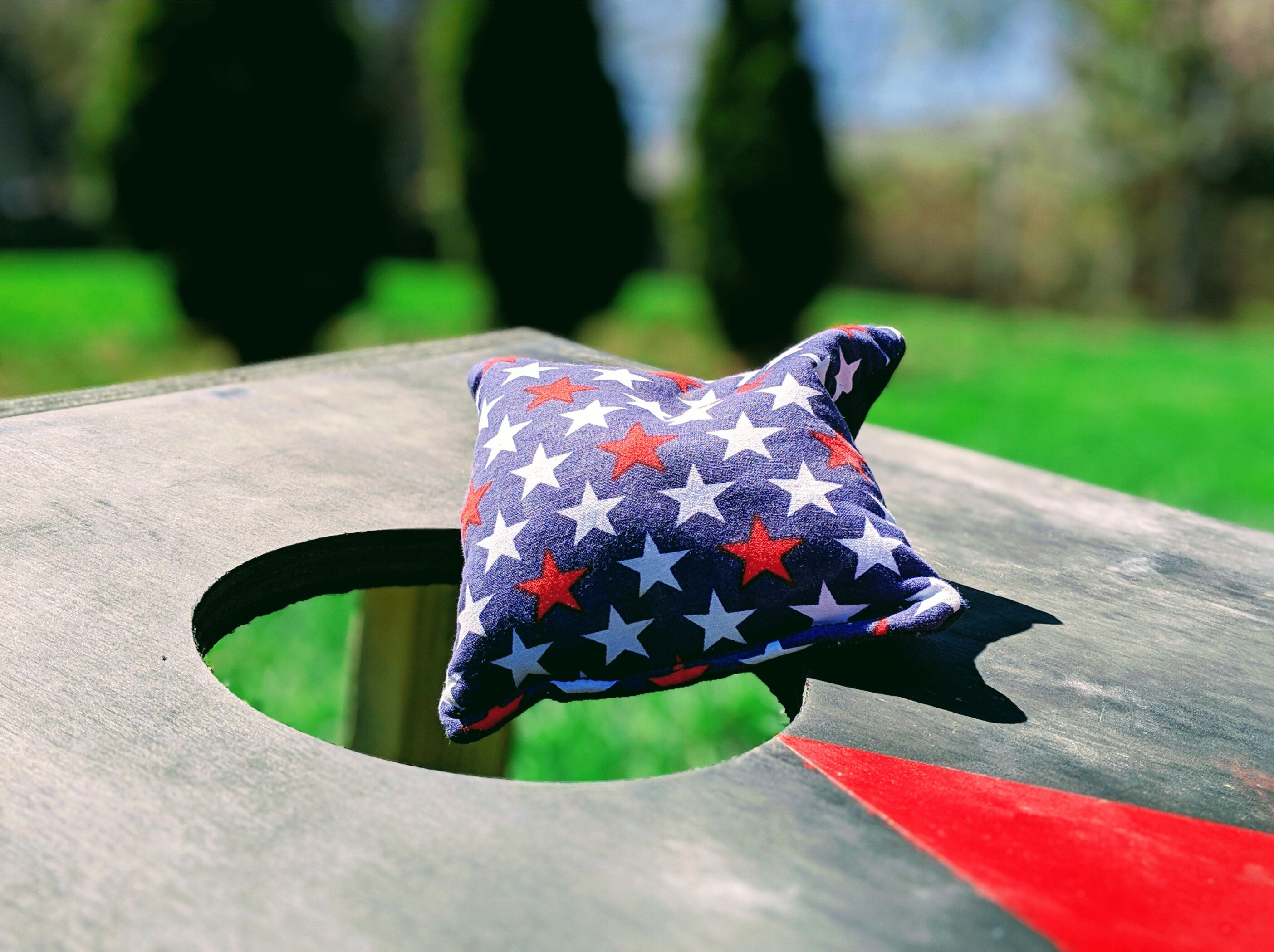 A pillow with a star pattern on a wooden bench.