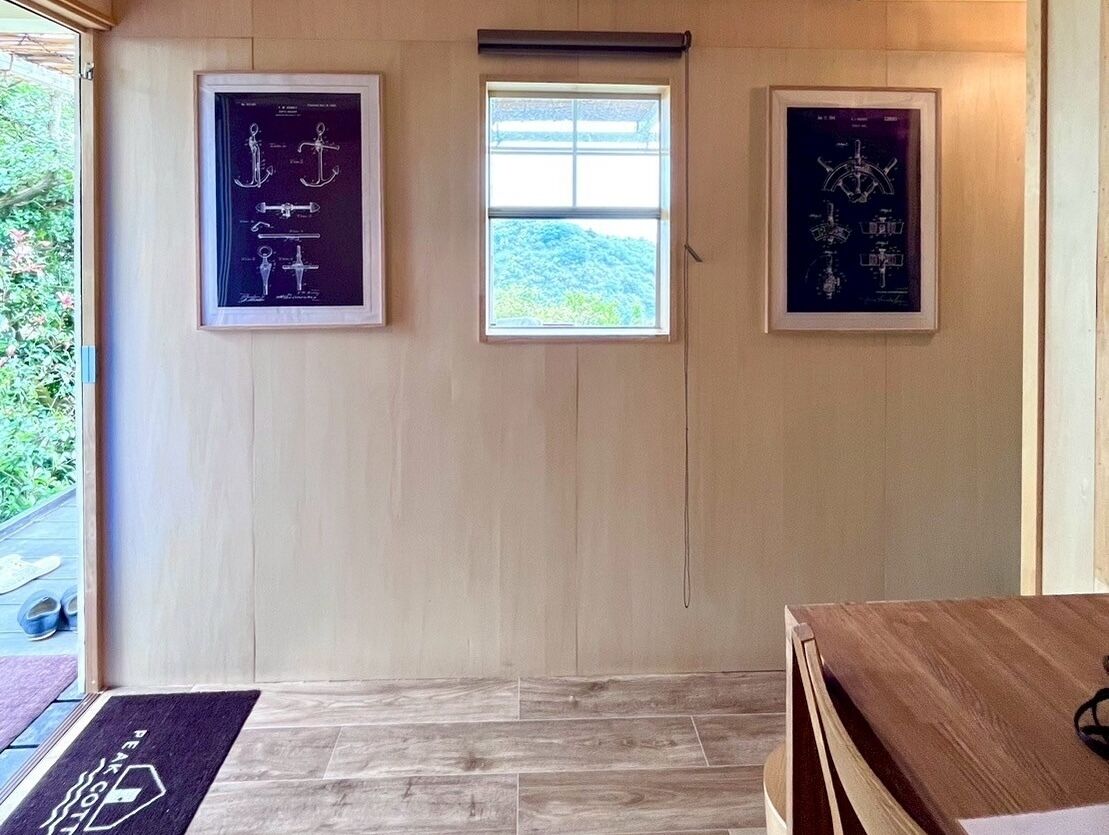 Une pièce avec une porte en bois, une petite fenêtre et deux schémas encadrés accrochés au mur.