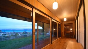 Un intérieur moderne avec de grandes portes-fenêtres coulissantes donnant sur un balcon offrant une vue sur la côte.