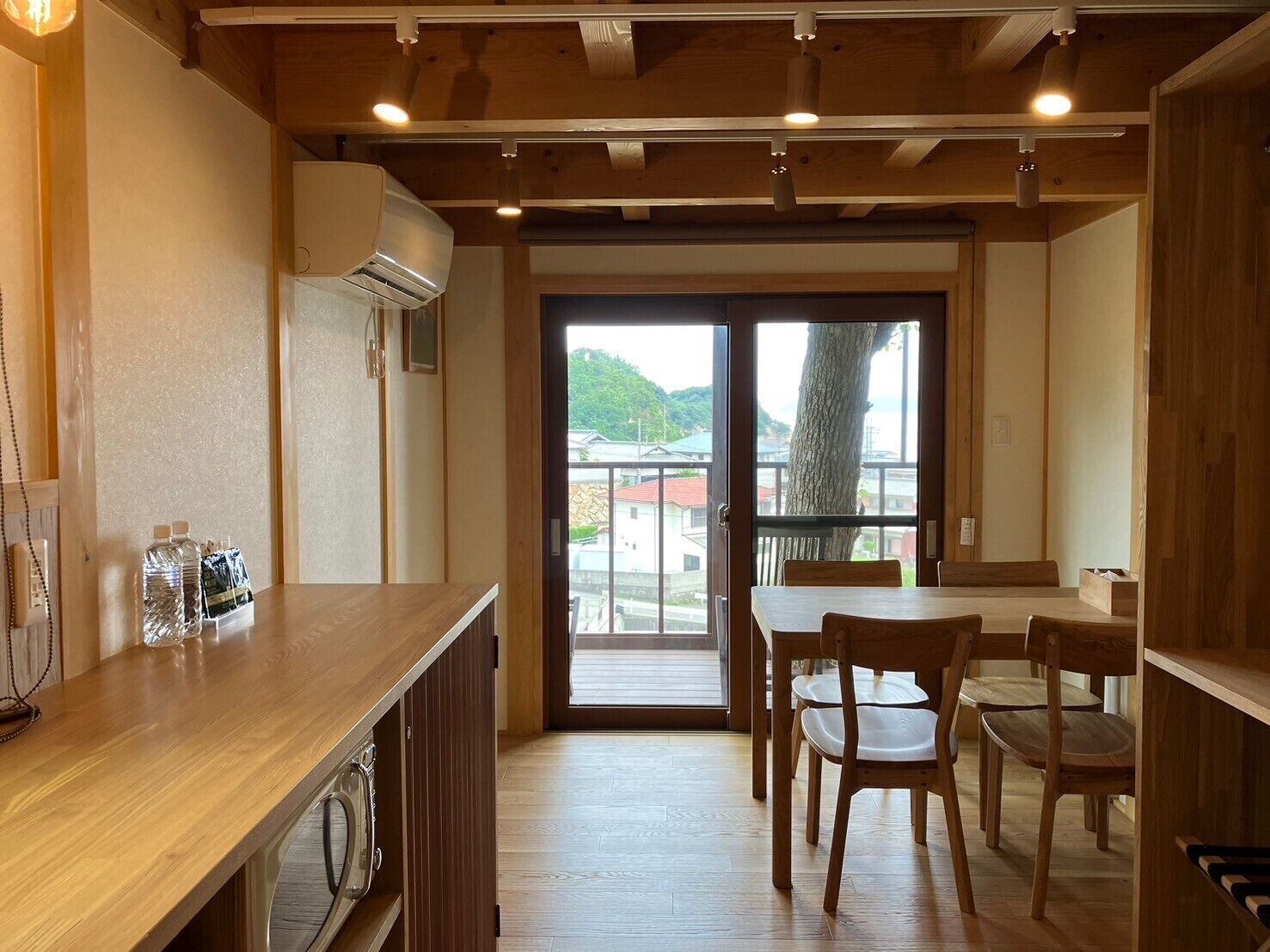 Un interior de madera con comedor, dispensador de agua y vistas al exterior.