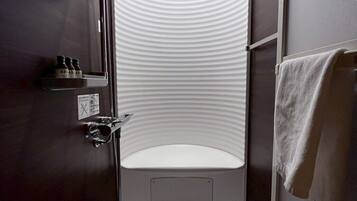 A small, modern bathroom with a shower, a toilet, and a sink.