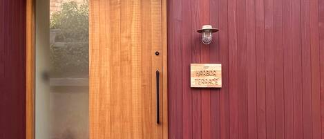A wooden door with a handle and a sign that reads "Harbor Terrace."