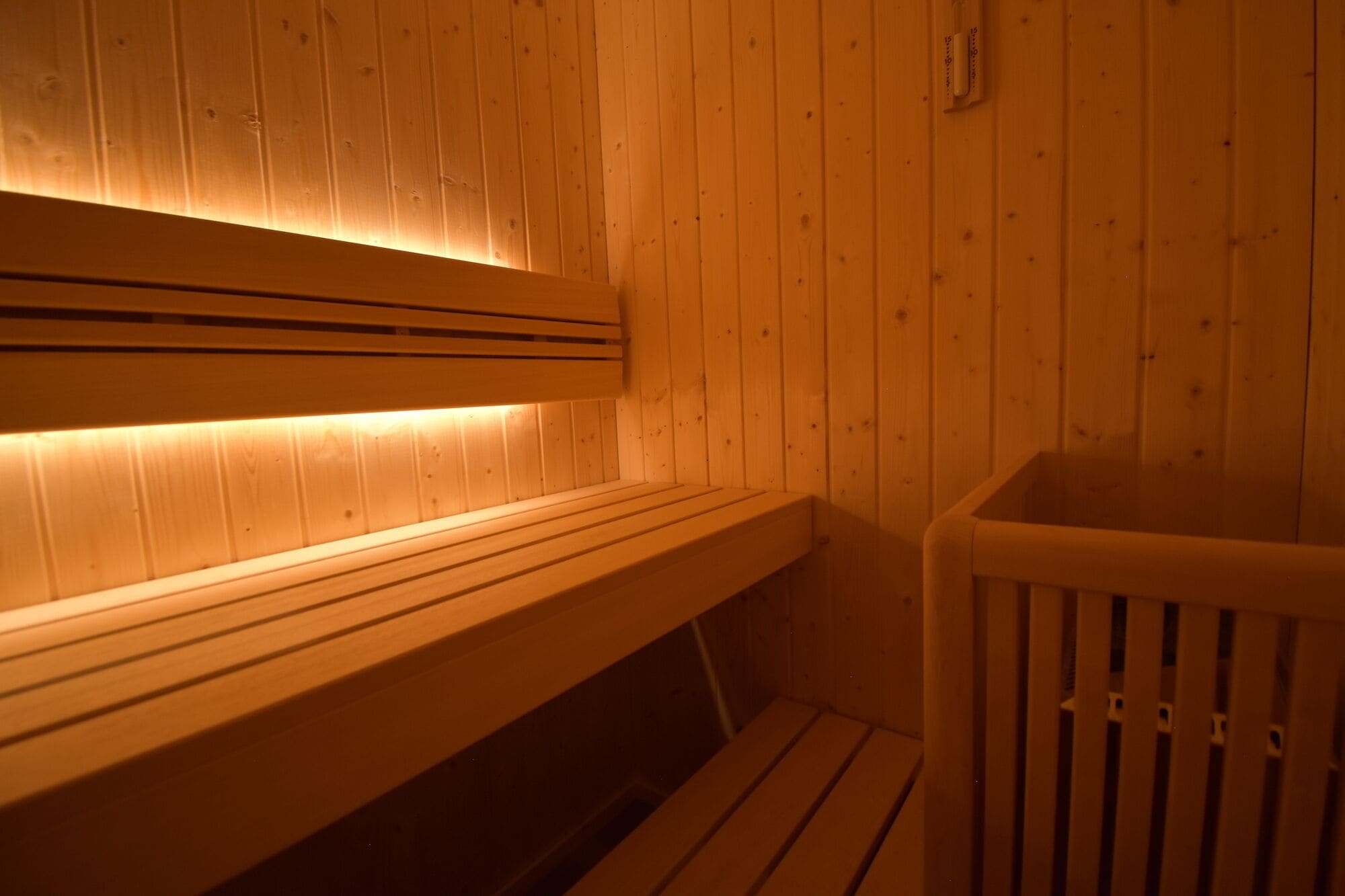 A wooden sauna with benches and a bench seat.