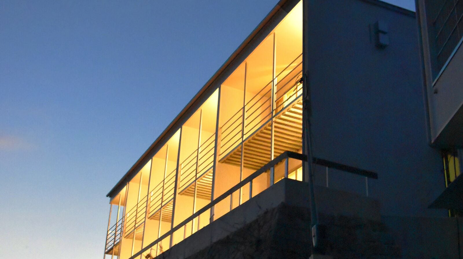 A modern building with large windows and a balcony.