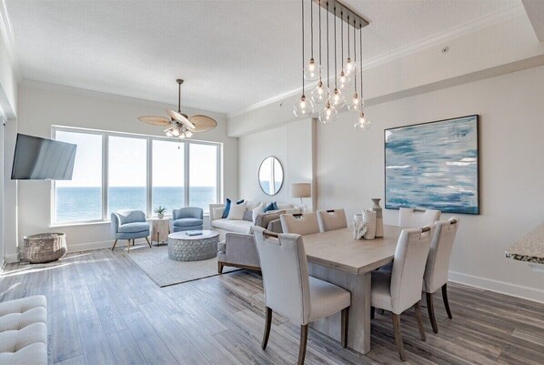 Relax in this stylish living area with a large dining table, flat-screen TV, and ocean views.