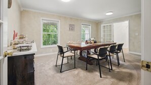 Comedor con una amplia mesa de madera, seis sillas y un centro decorativo.