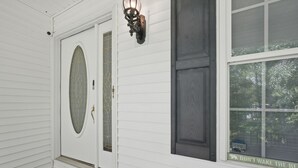 Una puerta blanca con un panel de vidrio y un aplique decorativo encima.