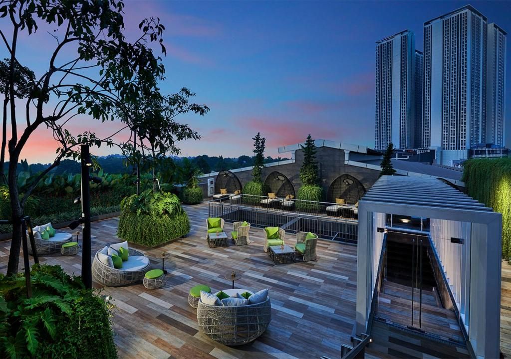 An outdoor patio area with seating arrangements and a view of tall buildings in the background.