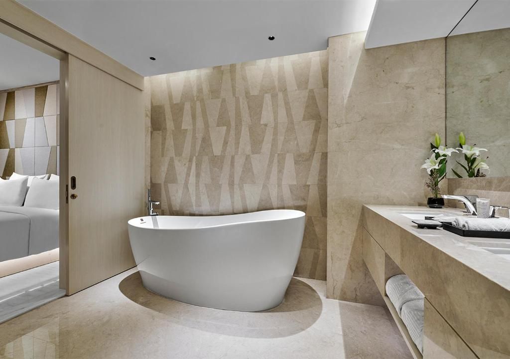 A modern bathroom with a freestanding bathtub, a large mirror, and a minimalist design.