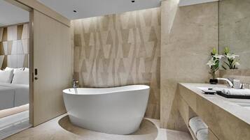 Un baño moderno con una bañera independiente, un espejo grande y un diseño minimalista.