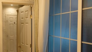 A room with a wooden chair, a door, and a window with blue-tinted glass. - The standard apartment shibuya B (Tokyo)