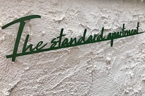 A wall with the text "The standard apartment" in green lettering. - The standard apartment shibuya B (Tokyo)