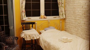 A small, cozy bedroom with a single bed, a chair, and a window with curtains. - The standard apartment shibuya D (Tokyo)