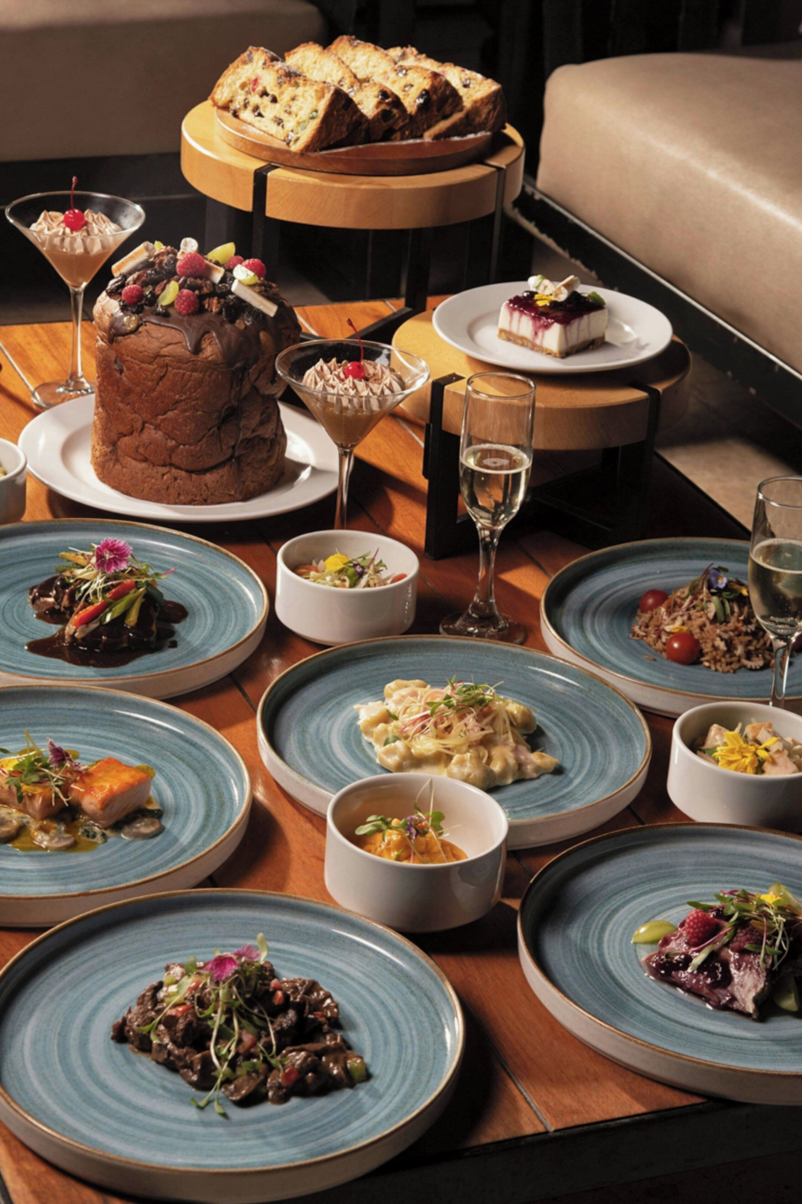 A table set with various dishes, including a chocolate cake and several plates of food, suggesting a dining area.