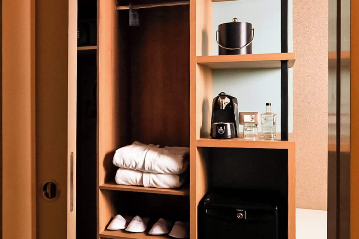 A walk-in closet with shelves, a hanging rack, and a storage unit.
