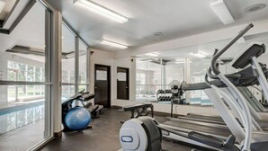 A gym with treadmills, exercise balls, and a mirrored wall. - 2 BR, 2 BA Newly Renovated Condo with Pool (Calgary)