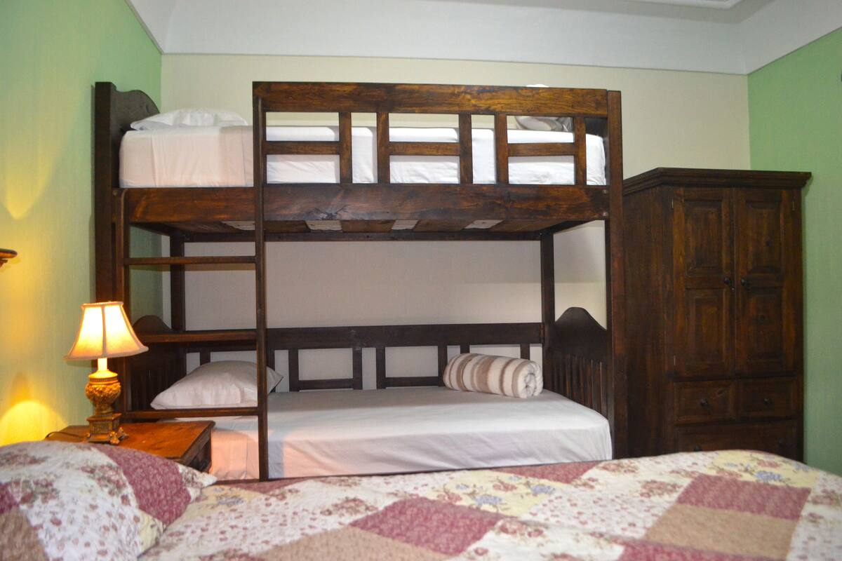 Escritorio, cortinas blackout y tabla de planchar con plancha