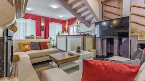 Una sala de estar moderna con sofá, mesa de centro y televisor.