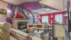 Una sala de estar moderna con chimenea, un comedor y una cocina.