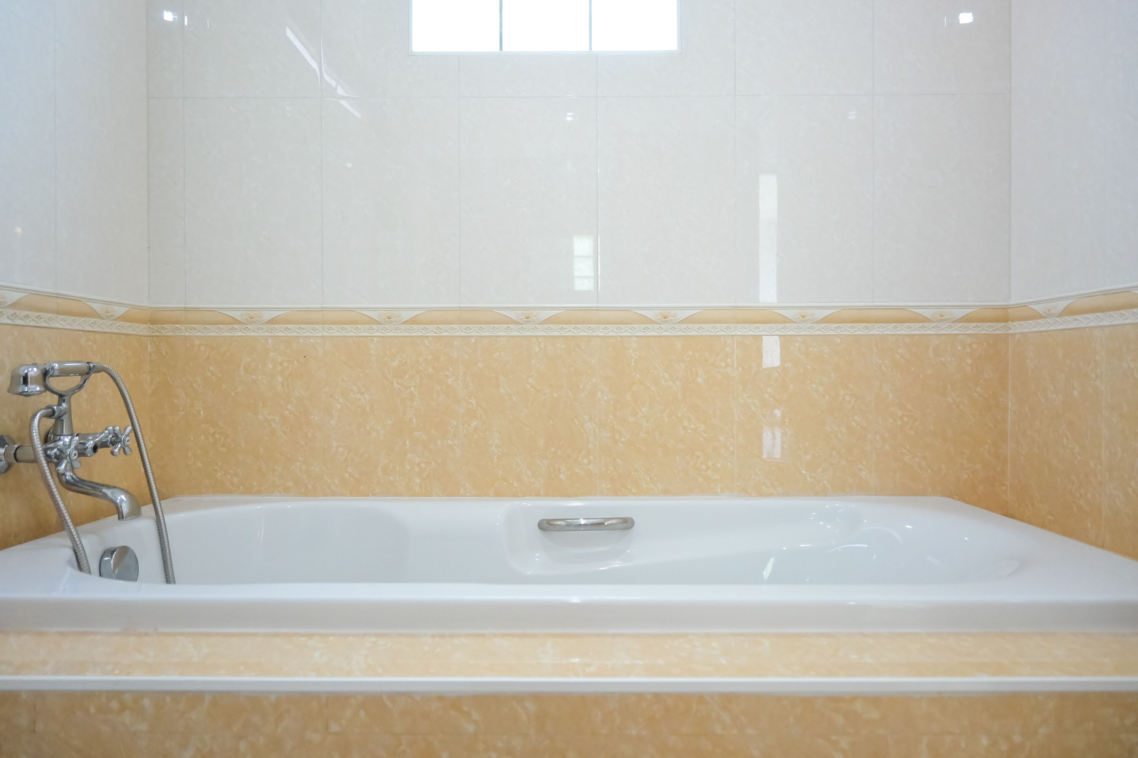 A bathroom with a bathtub, a shower, and a window.