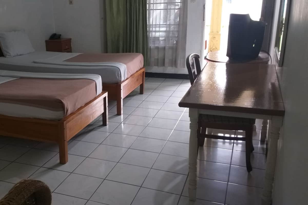 Une pièce avec deux lits en bois, une petite table et une chaise.