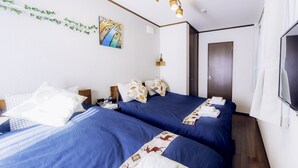 A hotel room with two beds, a painting on the wall, a television, and a door. - Nestay Suite Tokyo Shibuya (Tokyo)