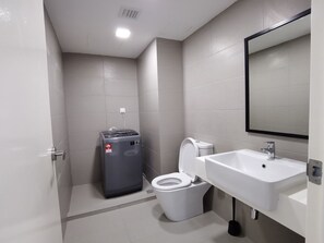 Ein modernes Badezimmer mit Toilette, Waschbecken und Wasserspender.