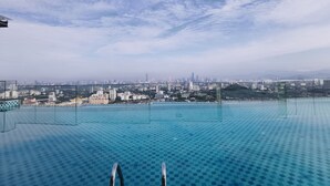 An infinity pool with a cityscape view, clear sky, and a distant mountain range. - Ekocheras Serviced Apartment by Duke Homes (Kuala Lumpur)