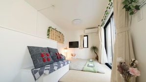 Ein kleines Schlafzimmer mit Bett, Nachttisch und einem kleinen Fenster.