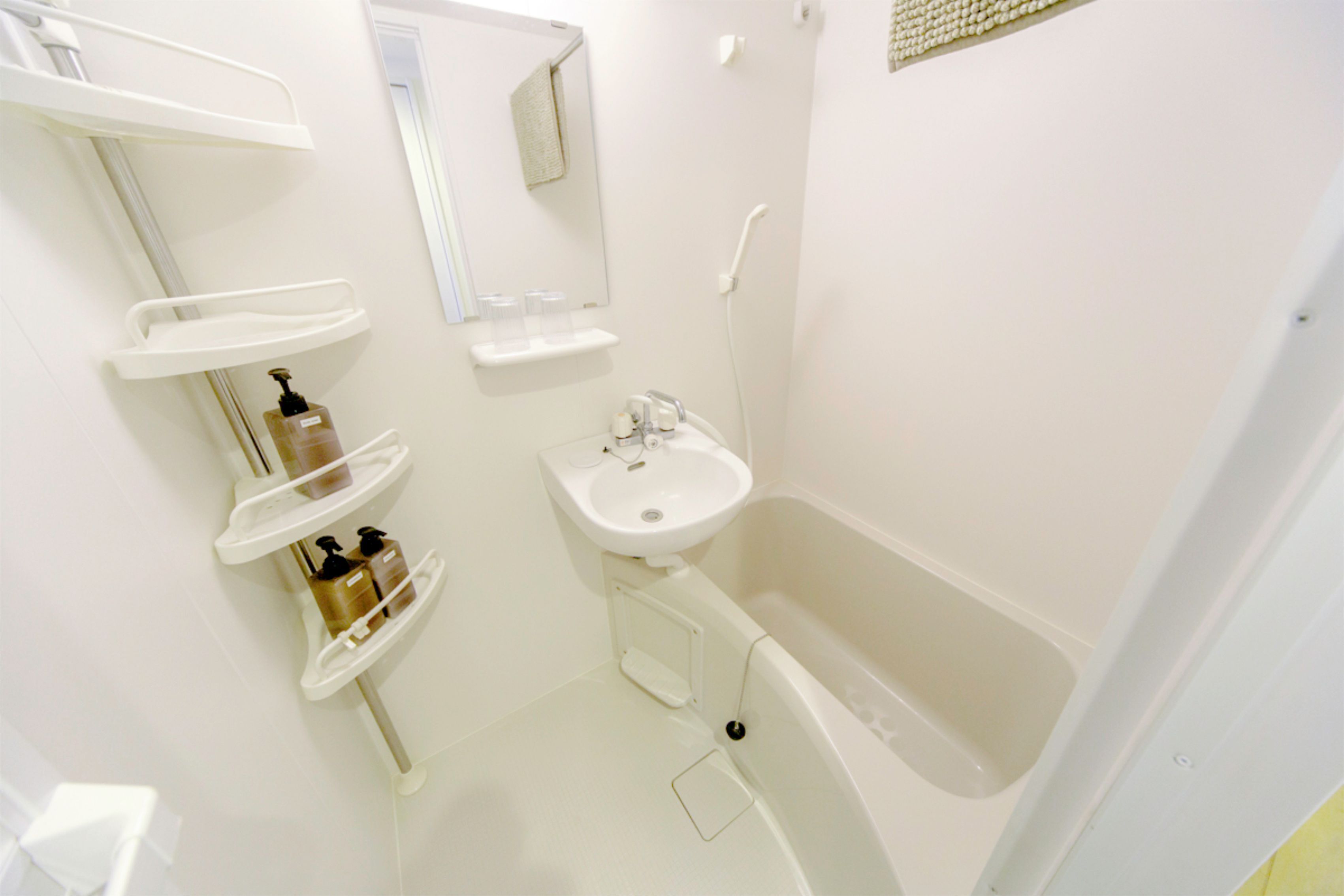 A modern bathroom with a bathtub, a sink, and multiple shelves for toiletries.