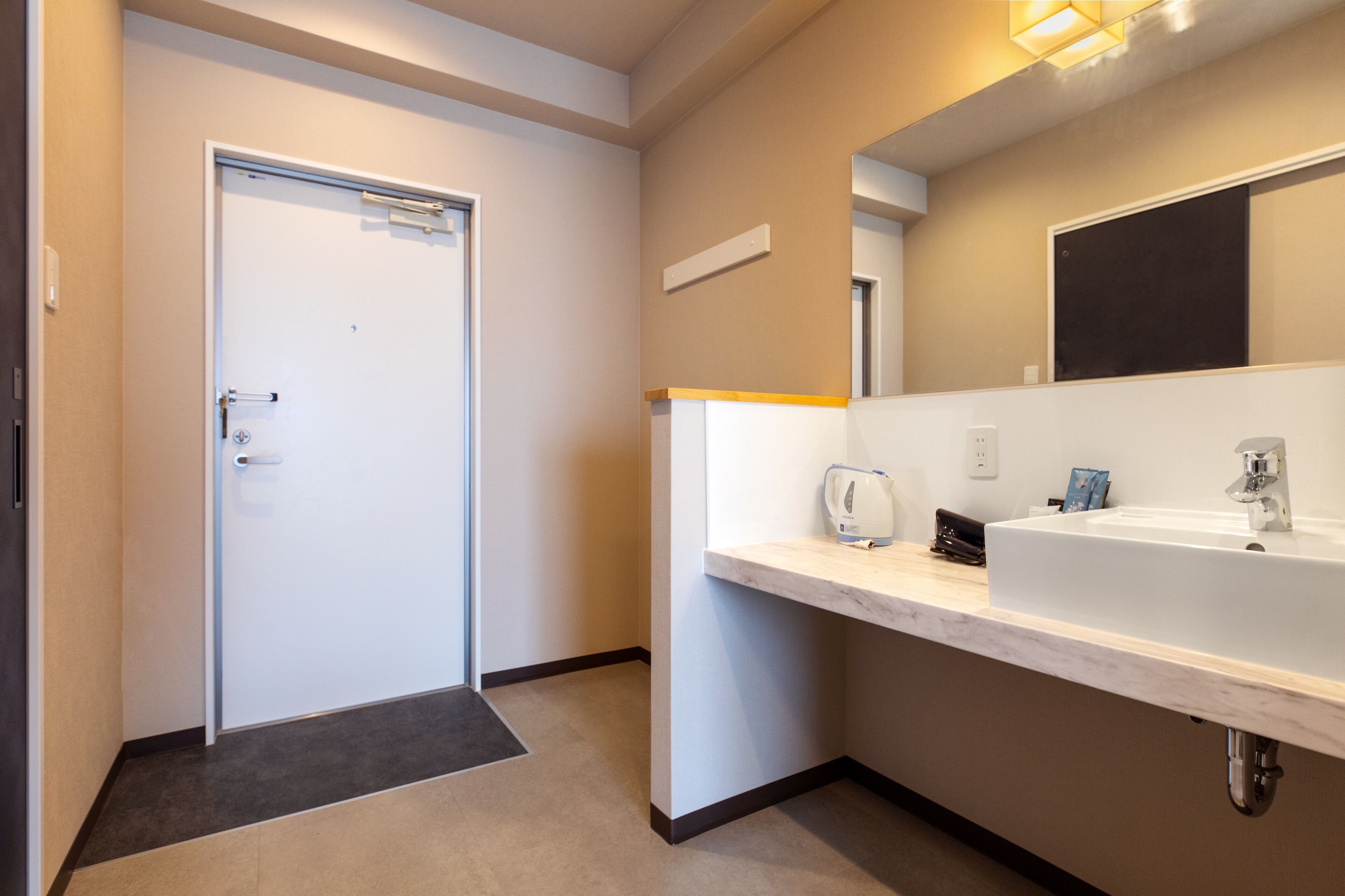 Un baño moderno con un lavamanos blanco, un espejo y un perchero para toallas.
