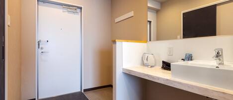 Un baño moderno con un lavamanos blanco, un espejo y un perchero para toallas.