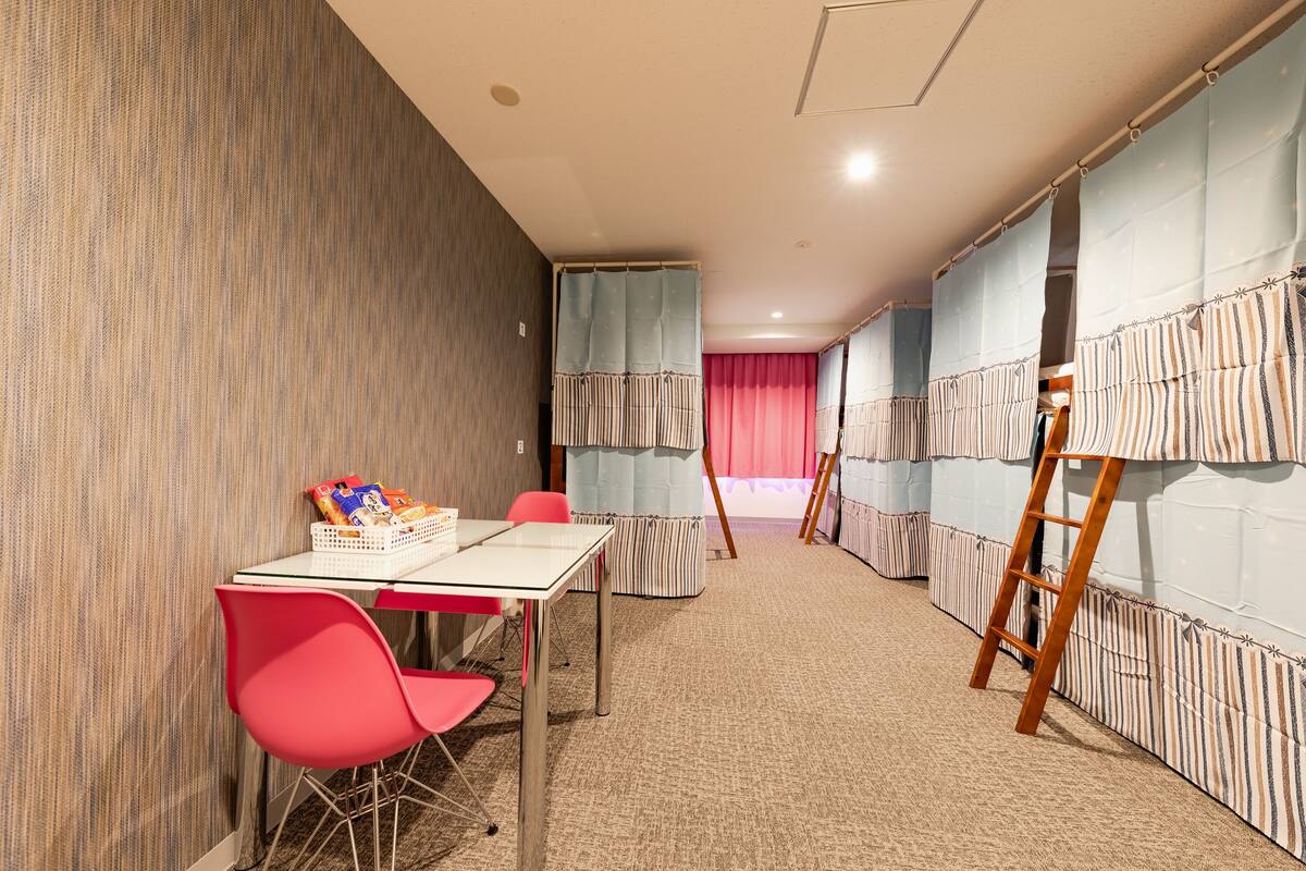 Une pièce avec un mur à rayures, une table avec des chaises et une échelle appuyée contre un mur.