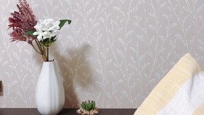 A white vase with flowers on a wooden surface against a patterned wall. - Nestle Suite Tokyo Shinokubo (Tokyo)
