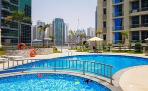 A swimming pool with a cityscape in the background.