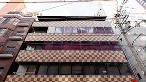A multi-story building with a checkered facade, balconies, and visible electrical infrastructure. - Nikko Inn Minamisenba 603 (Osaka)