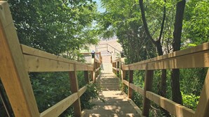 A wooden bridge with railings leading to a beach. - Greenlodge Cottage - Grand Bend, Ontario, Canada (Zurich)