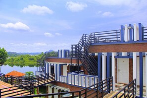 Un edificio de varios niveles con escaleras, barandillas y vista a un lago.