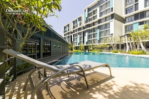 A modern hotel with a swimming pool, lounge chairs, and a well-maintained garden. - Core Suite KLIA By DreamScape (Sepang)