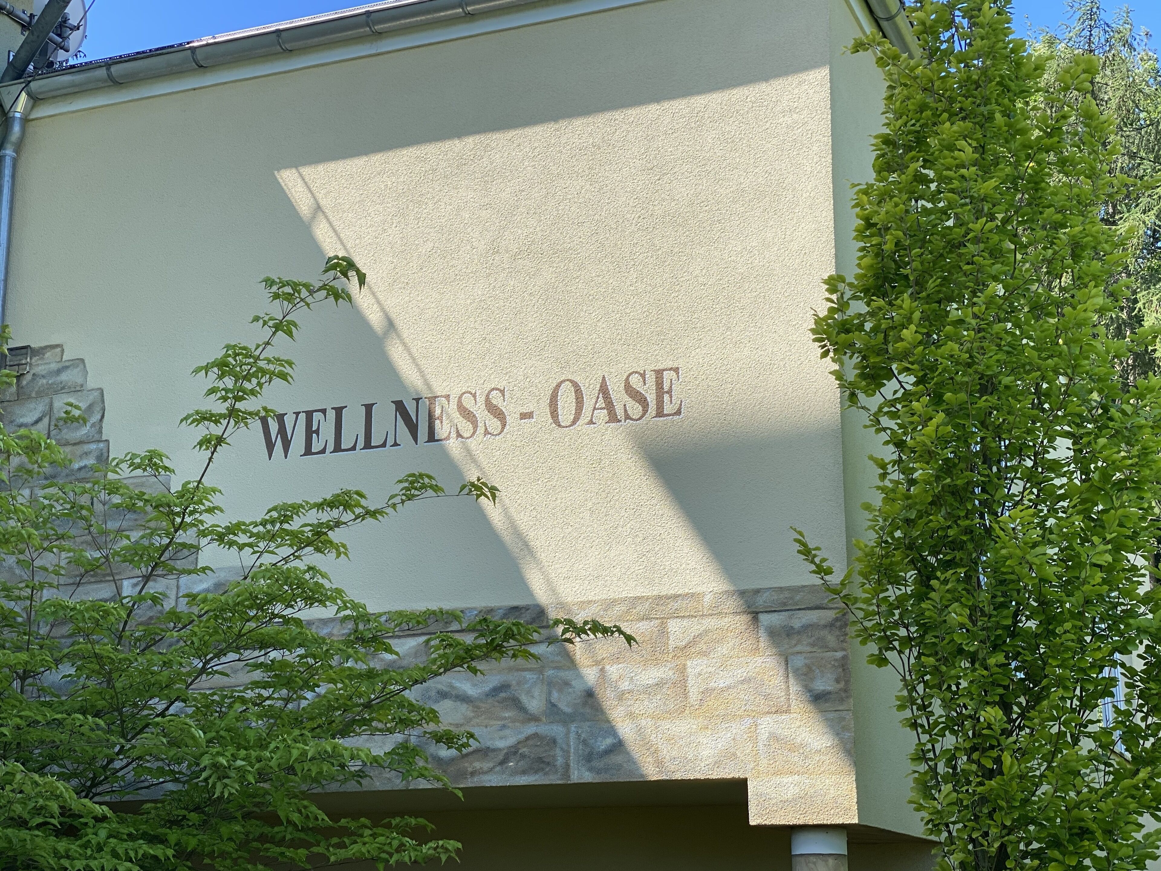 A building facade with the words "WELLNESS-OASE" prominently displayed.