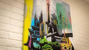 Un mural colorido con elementos arquitectónicos y una torre destacada.