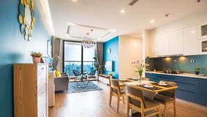 Un apartamento moderno con comedor, cocina y un amplio ventanal con vistas a la ciudad.
