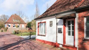 A traditional building with a red brick facade, a white door, and a small window.
